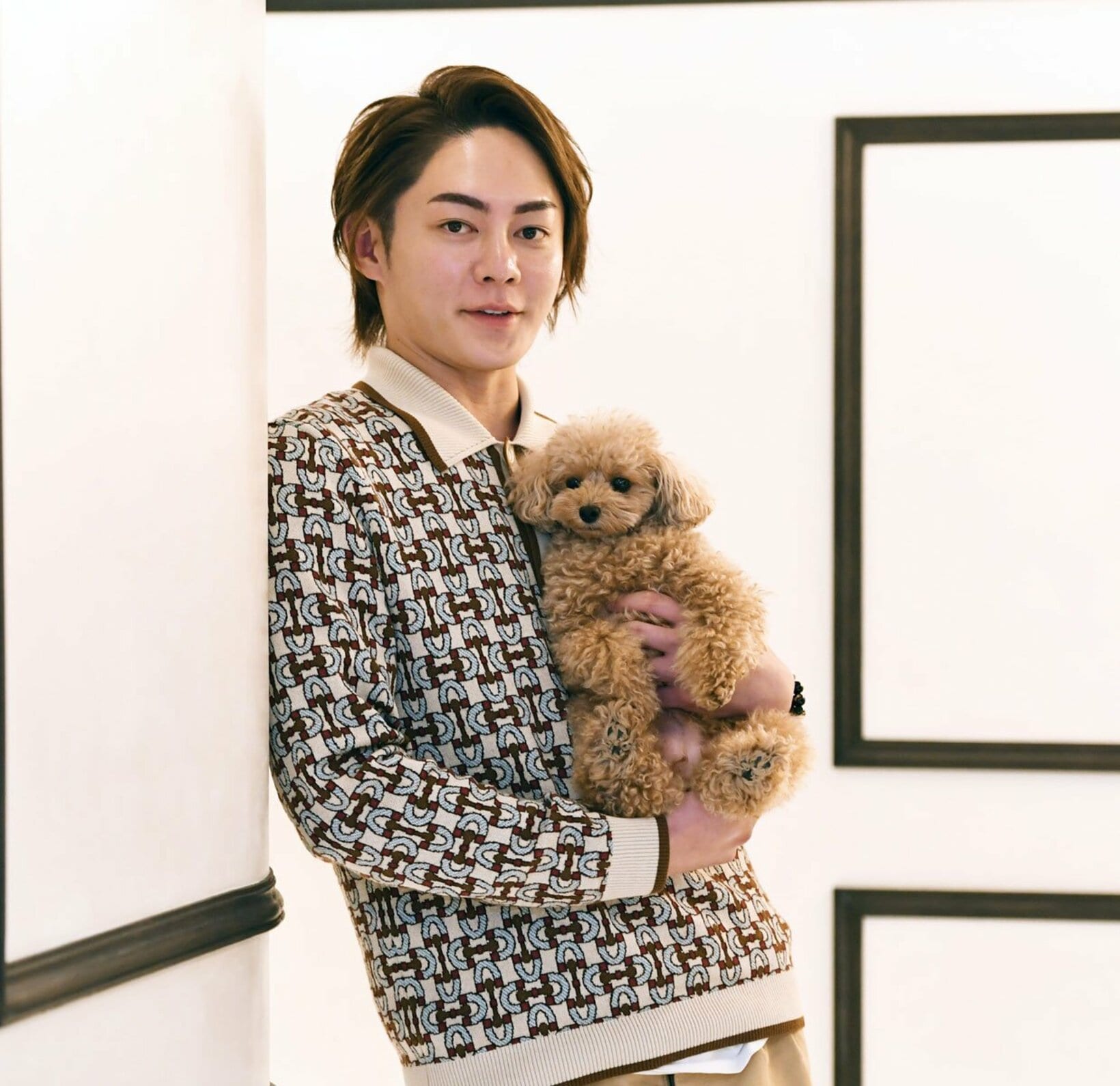 愛犬のトイプードルを抱く三崎優太氏