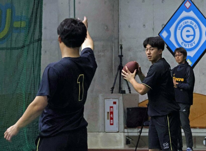 アメフトのボールでキャッチボールする森下翔太と立石正広（右）