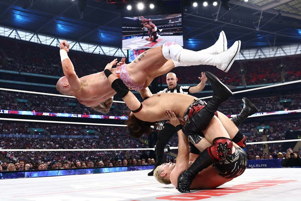 竹下幸之介(中)はオカダ・カズチカ(下)を丸め込みながらカイル・フレッチャーをジャーマンで投げる(ⒸAll Elite Wrestling)