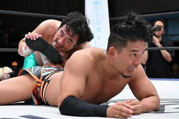 クロス式アンクルホールドでとらえてギブアップを奪った田口隆祐（奥）