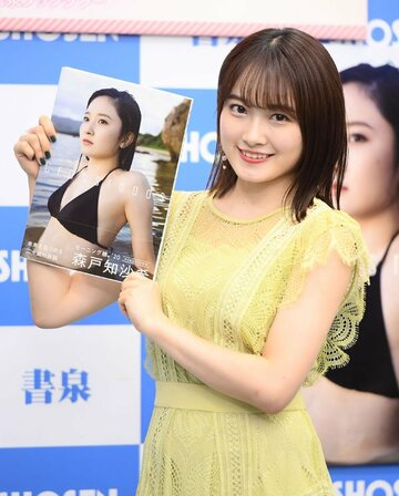  写真集を手にする森戸知沙希