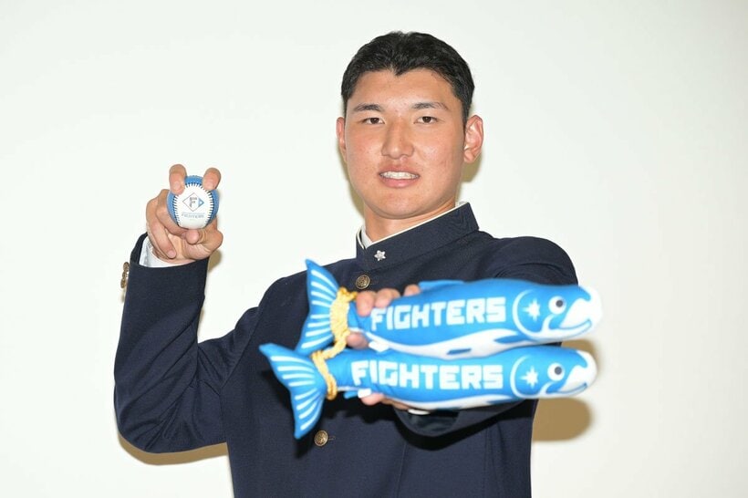 日本ハムグッズを手に記念撮影する山梨学院・菰田