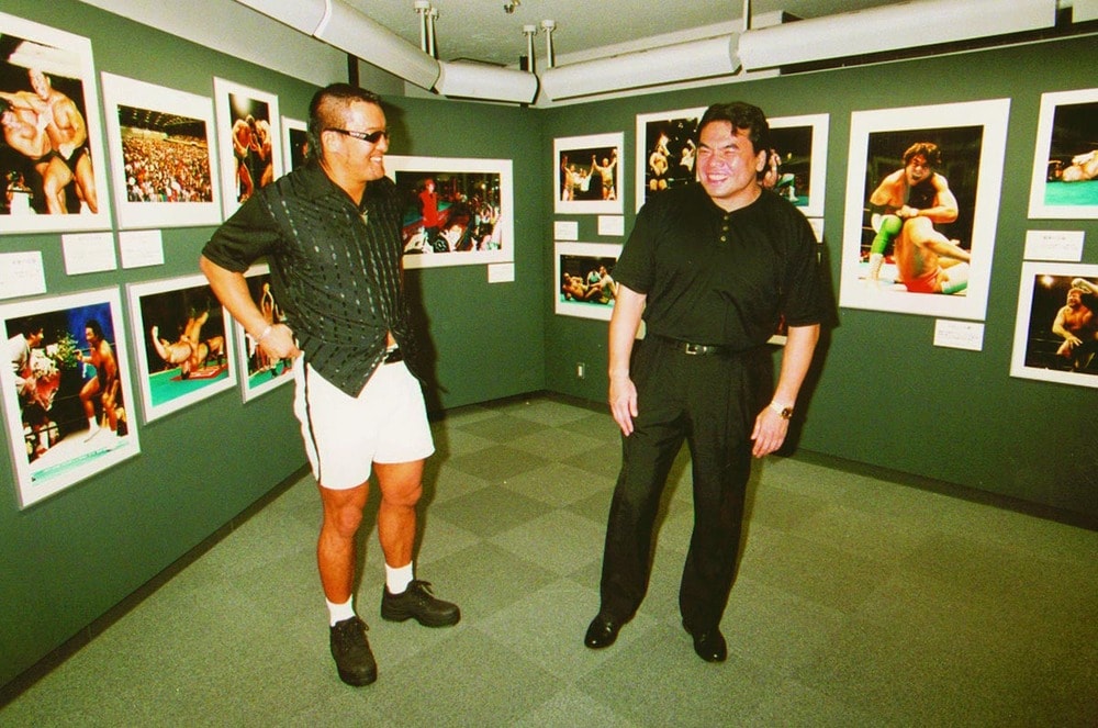 笑顔で談笑する蝶野(左)と三沢(1998年8月、銀座の富士フォトサロン)