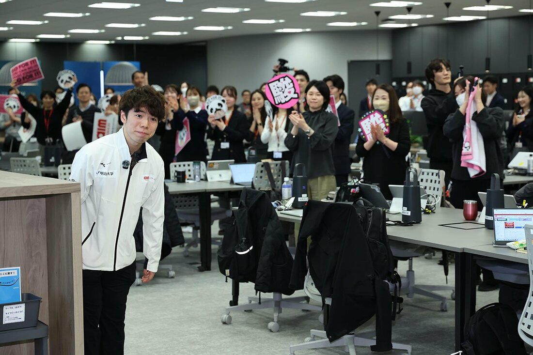 多くの社員に出迎えられた佐藤駿(左)