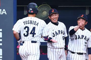 本塁打を放った吉田を迎える井端監督