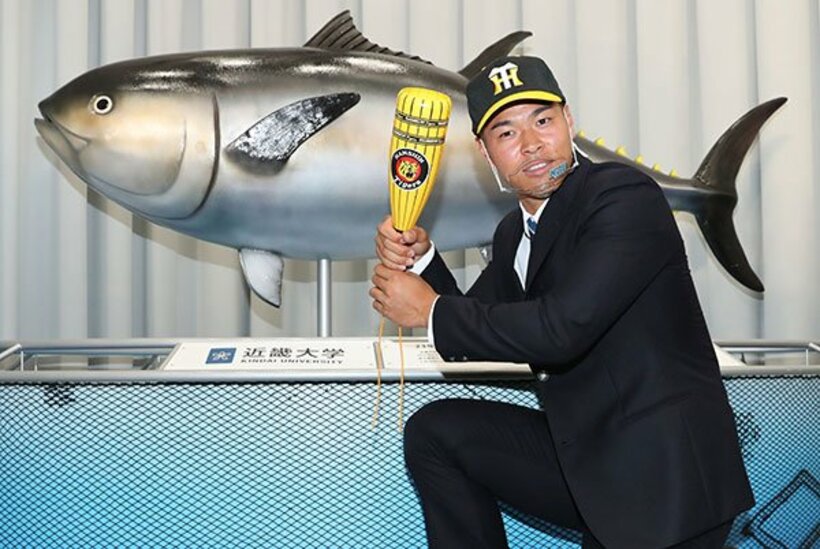  近大マグロの模型の前でポーズを決めた近大・佐藤