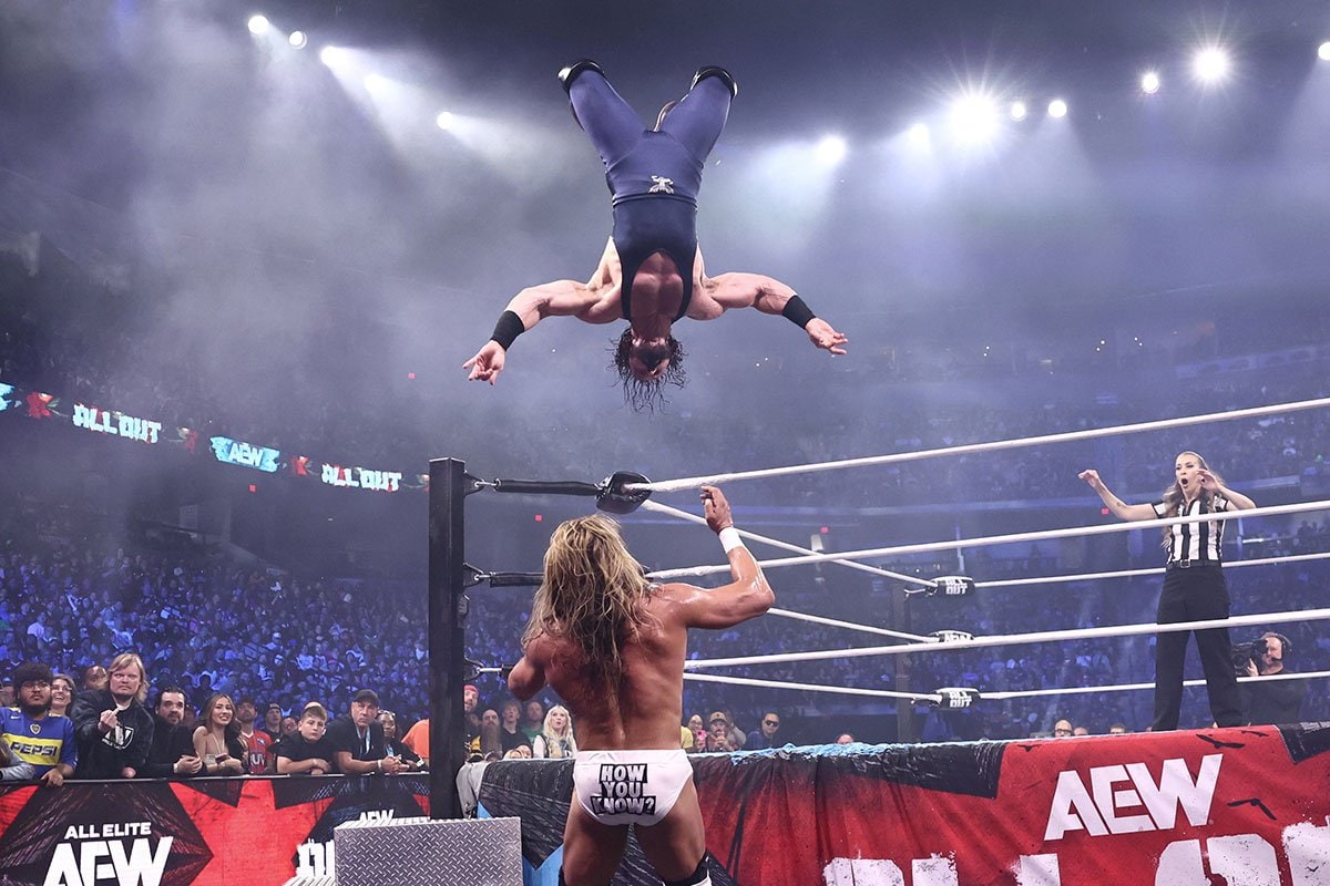 場外のアンドラデ・エル・イドロ(下)にケブラーダを仕掛けるPACさんo（©All Elite Wrestling）