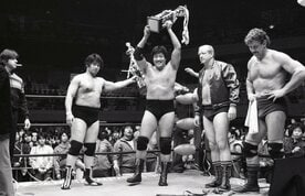  試合後のセレモニーで笑顔でトロフィーを掲げる鶴田。左隣の天龍はぶぜんとした表情（東スポWeb）