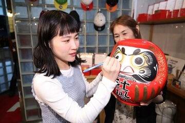 だるまに目を書き入れる辻凪子
