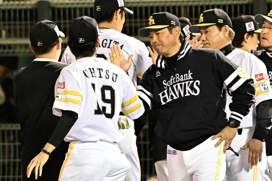 勝ち投手の大津亮介とタッチする小久保裕紀監督