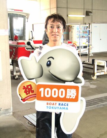 通算１０００勝のボードを掲げる待鳥雄紀