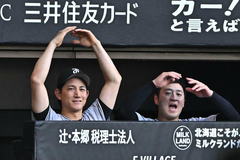 安打を放った丸佳浩に、ベンチから「丸ポーズ」を送る巨人・小林誠司(左)。右は岸田行倫
