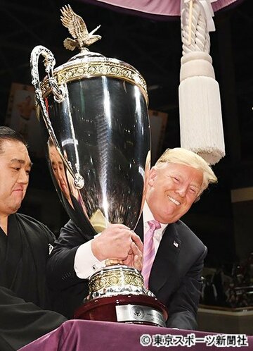  米国大統領杯を満面の笑みで持ち上げるトランプ大統領