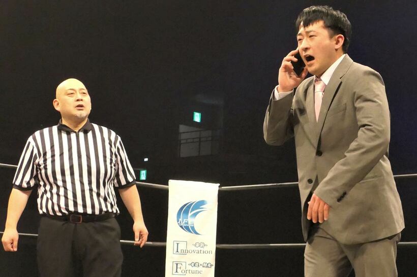 商談（試合）中にかかってきた電話に出る新橋二郎（右）