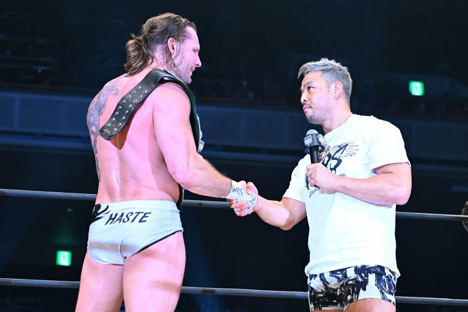 Ｖ１戦の相手に指名したKENTA(右)と握手するシェイン・ヘイスト