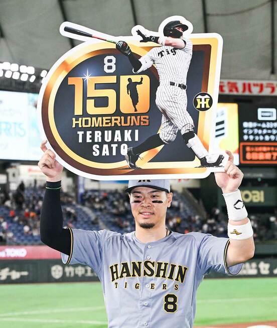 通算150号本塁打の記念ボードを掲げる佐藤輝明