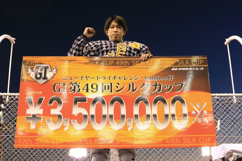 長田稚也は賞金ボードを手にガッツポーズ