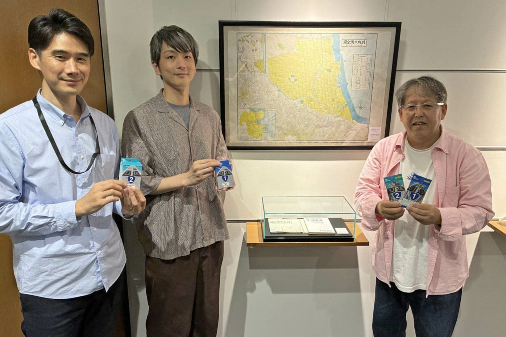 笑顔で渡辺広明氏（右）を迎えてくれたゼンリンの（左から）長縄樹里氏、高橋圭佑（中央は同社創業時にの別府の地図『年刊別府』）