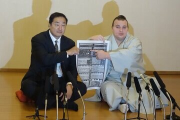 番付表のしこ名を指さす安青錦（右）と安治川親方