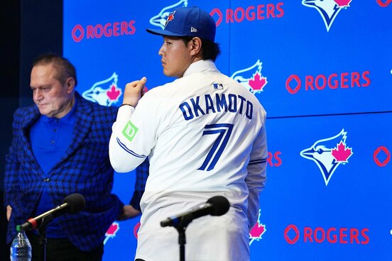 入団会見で背番号７のユニホーム姿を披露した岡本和真（ロイター）