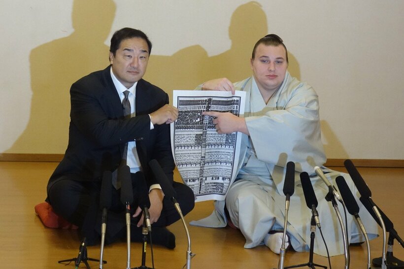 番付表のしこ名を指さす安青錦（右）と安治川親方