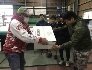  ステーキ肉が入った段ボールを若手に渡す藤田（左）