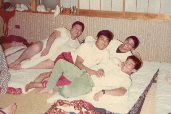 高校３年当時に友人らと映る谷津嘉章（中央・本人提供）