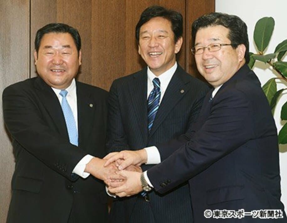 末沢オーナー（右）、竹田社長（左）とがっちり握手をかわす栗山監督