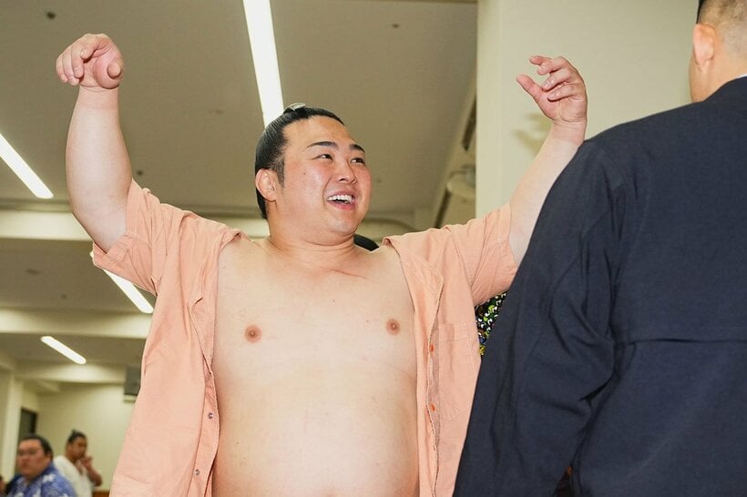 13日目に勝ち越しが決まり、支度部屋で笑顔の炎鵬(左)