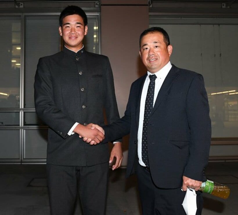  八木監督(右)と握手を交わす福岡大大濠・山下舜平大