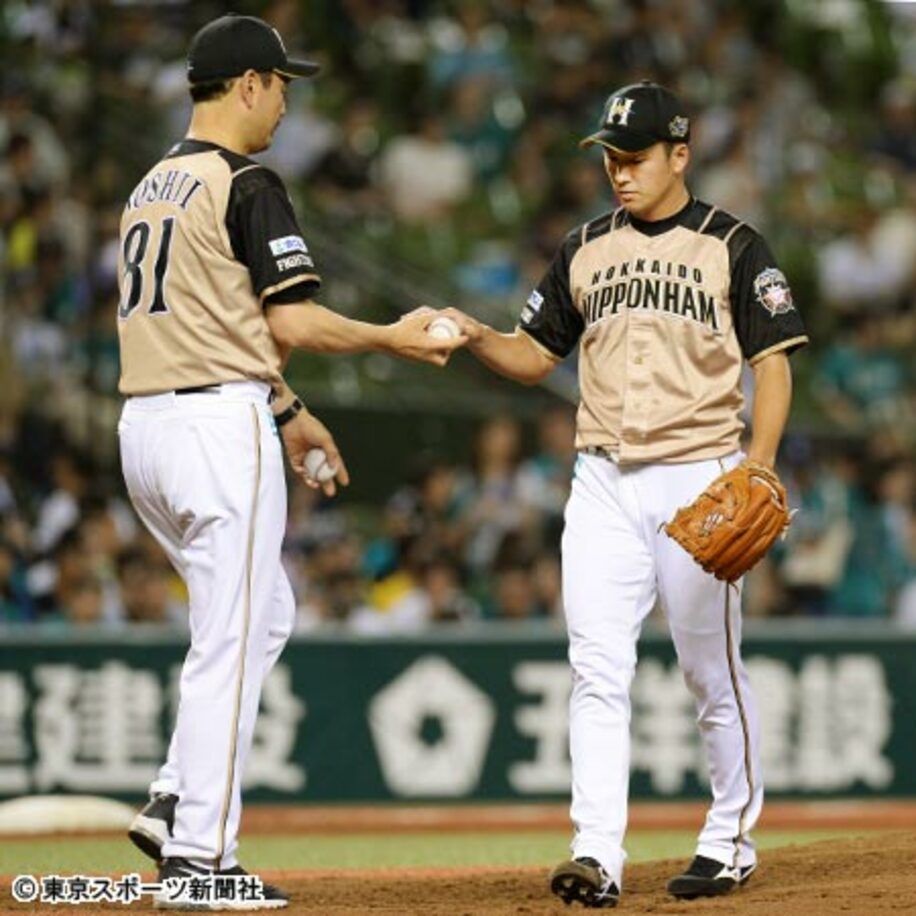 吉井コーチ（左）にボールを渡し、４回途中でマウンドを降りる斎藤