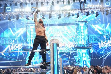 コーナーに上がりベルトを掲げるローマン・レインズ（©WWE）