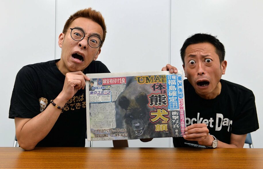  “イヌの顔をしたクマ”騒動を報じた７月１１日付本紙を手にする三浦（左）と倉本