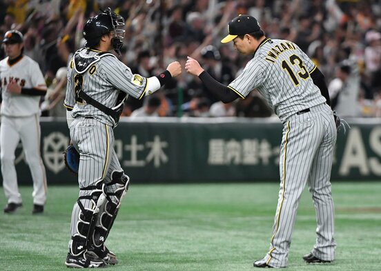 巨人を下しグータッチする梅野（左）と岩崎