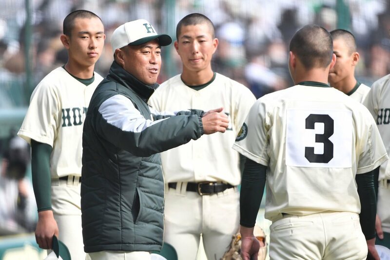 ベンチ前でナインに指示を出す報徳学園・大角監督
