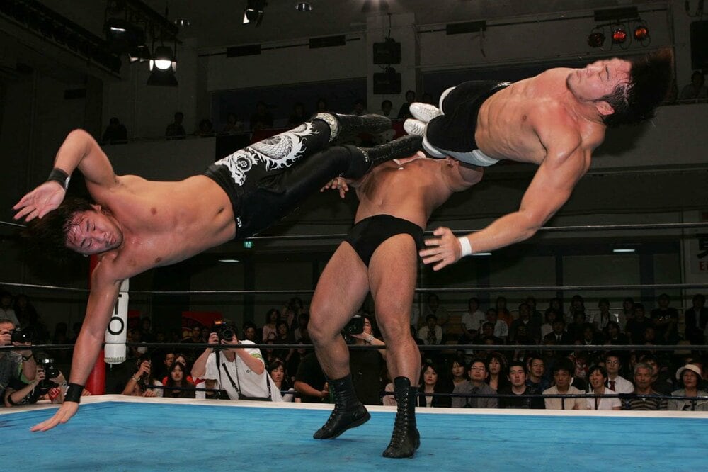 合体ドロップキックを繰り出す中邑真輔（左）と棚橋弘至（右）