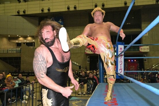 身長213cmのタロース(左)にビッグブーツを放つ宮原健斗