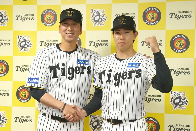 支配下登録が決まり、藤川球児監督（左）と握手する工藤泰成