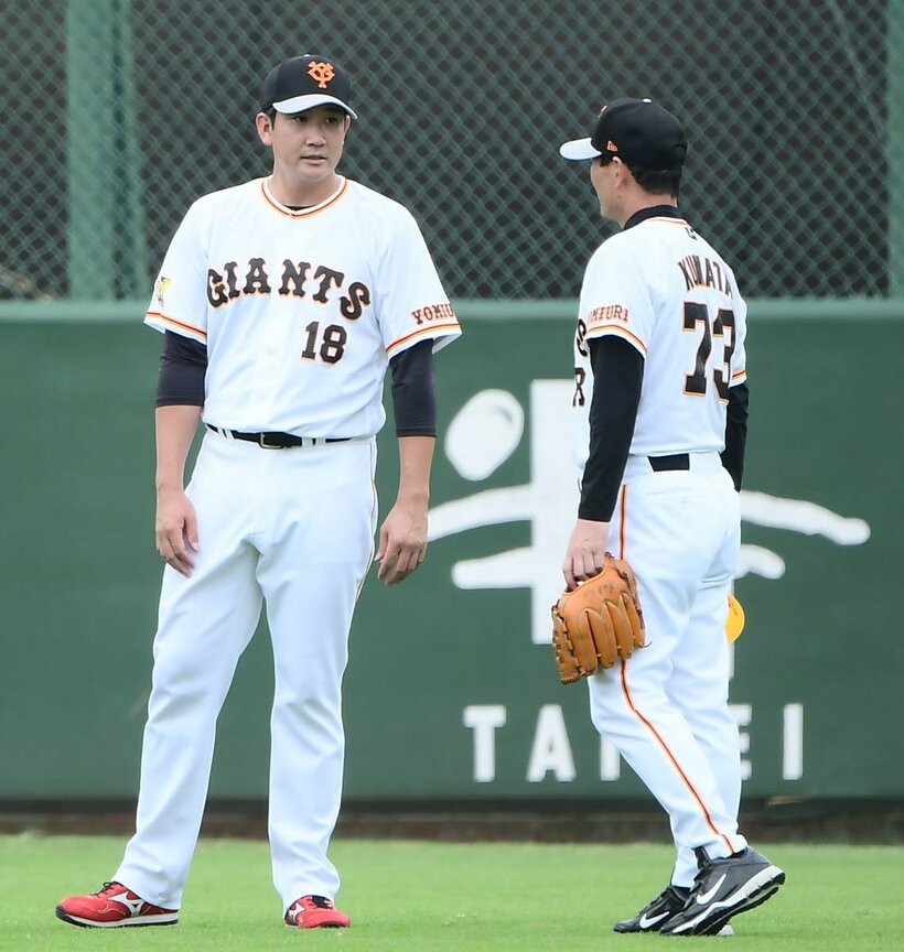  桑田投手チーフコーチ補佐と話す菅野（左）