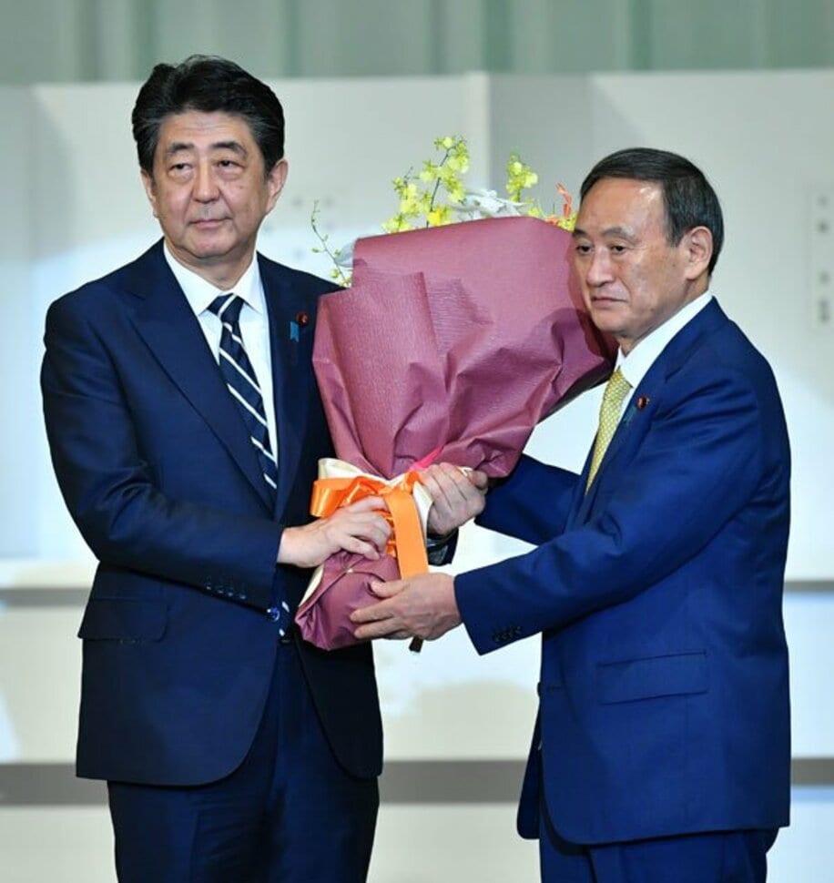  安倍首相から花束を渡される自民党・菅新総裁