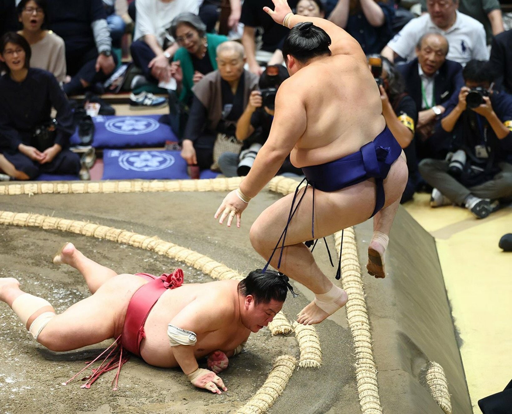 あわや…土俵際で大ジャンプする大の里(右)