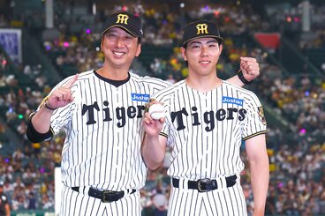 プロ初勝利を挙げ、藤川監督(左)と記念撮影をする阪神・工藤泰成