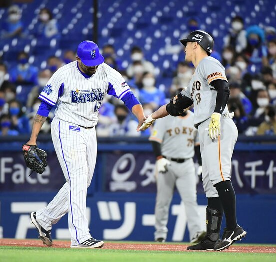  巨人・梶谷(右)にタッチするDeNA・エスコバー