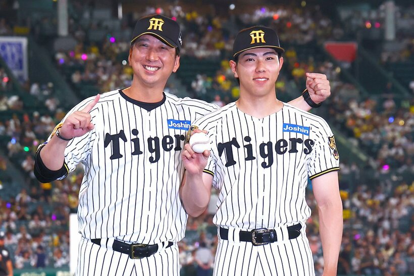 プロ初勝利を挙げ、藤川監督(左)と記念撮影をする阪神・工藤泰成