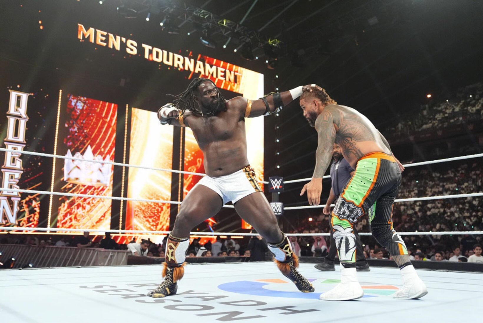 オバ・フェミ（左）はジェイ・ウーソにパンチを叩き込む©WWE