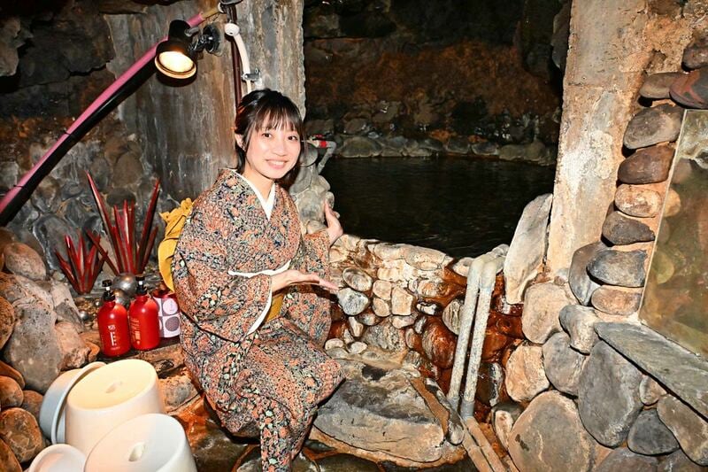 一福荘の名物、岩穴風呂を紹介する梅崎さん
