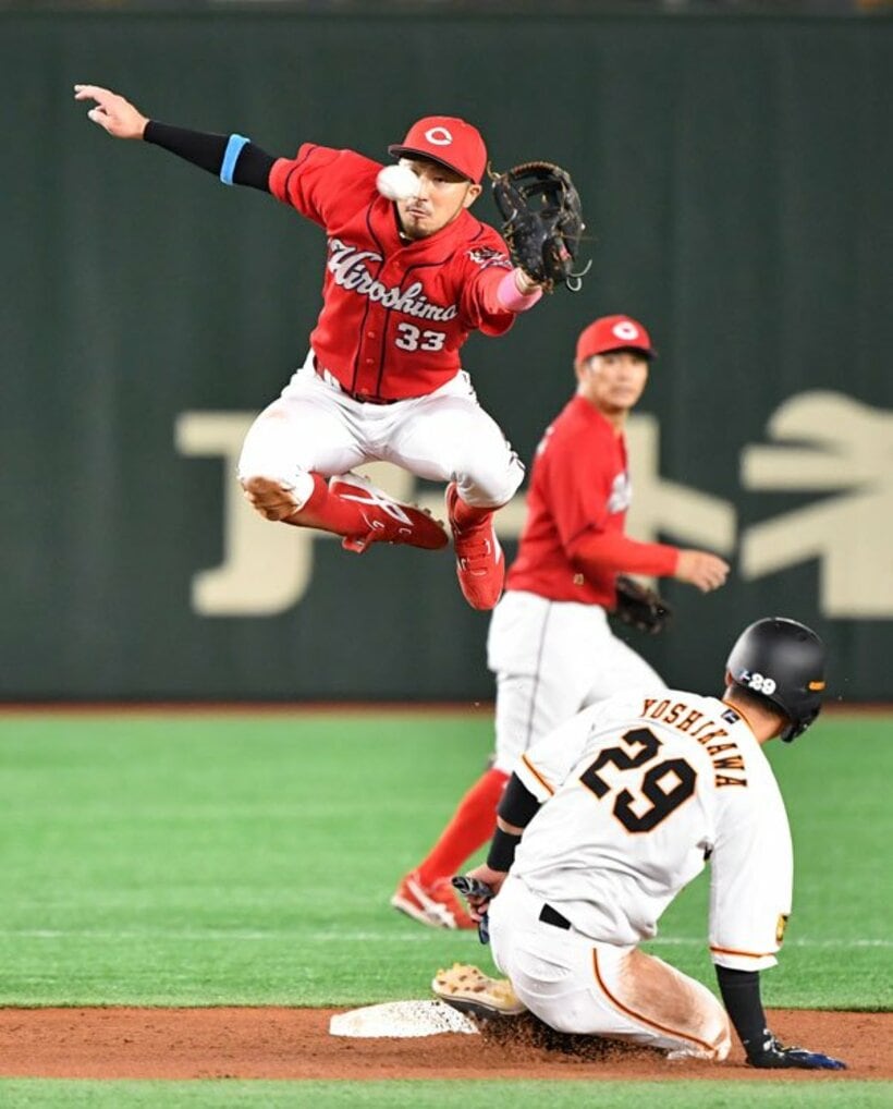  盗塁した巨人・吉川尚のスライディングをかわす広島・菊池涼（左）