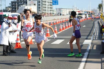 トップでタスキをつなぐ中大3区・中野翔太(左)と4区・吉居駿恭（代表撮影）
