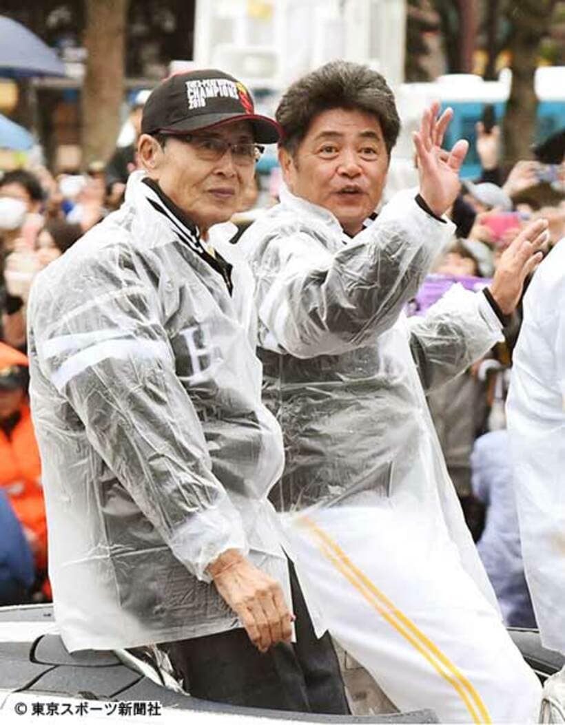  祝賀パレードで沿道のファンに手を振る工藤監督。左は王貞治球団会長