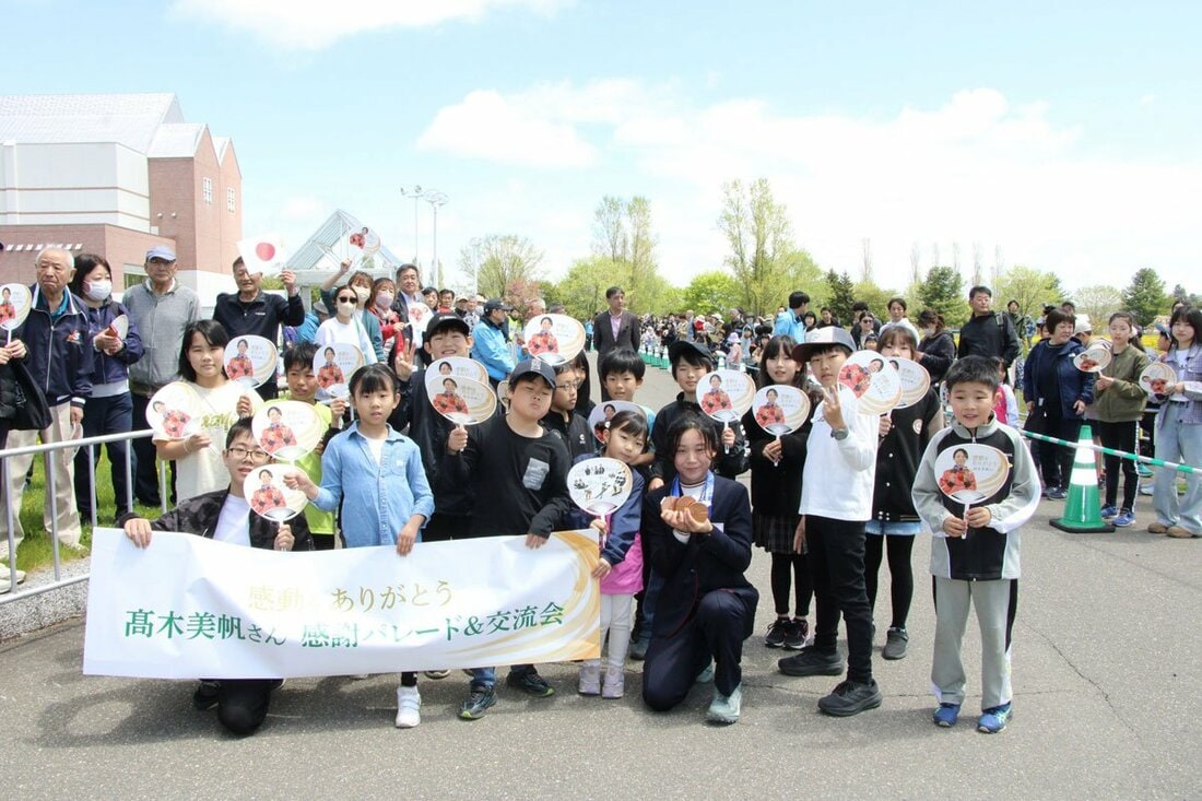 故郷・幕別町でのパレードで、子供たちと写真に収まる高木美帆さん（幕別町提供）